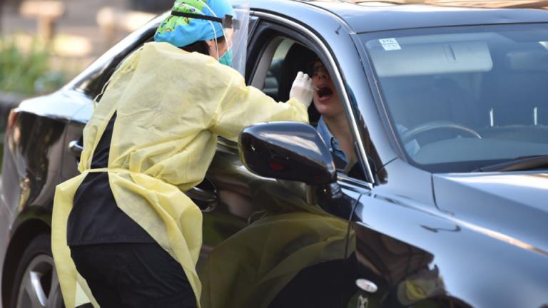 A medic takes a nasal swab from a driver at a drive-through testing centre for the COVID-19 coro<em></em>navirus in Sydney