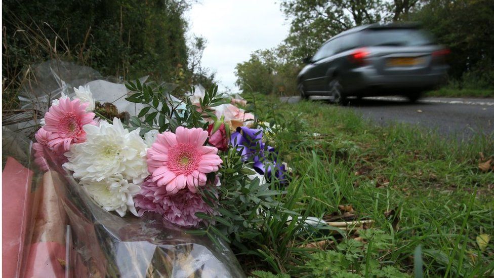 Floral tributes lay on the roadside near RAF Croughton in Northamptonshire, central England on October 10, 2019, at the spot wher<em></em>e British motorcyclist Harry Dunn was killed