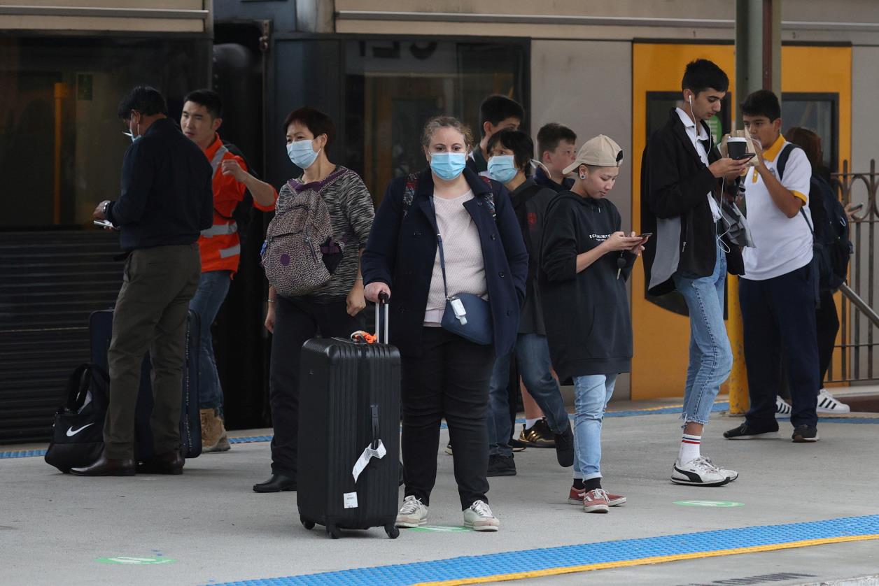 People, some wearing protective face masks, stand on a train platform at Central Station after new public health regulations were announced for greater Sydney, including compulsory mask-wearing on public transport, following the emergence of new cases of the coro<em></em>navirus disease (COVID-19) in Sydney, Australia, May 6, 2021.  REUTERS/Loren Elliott