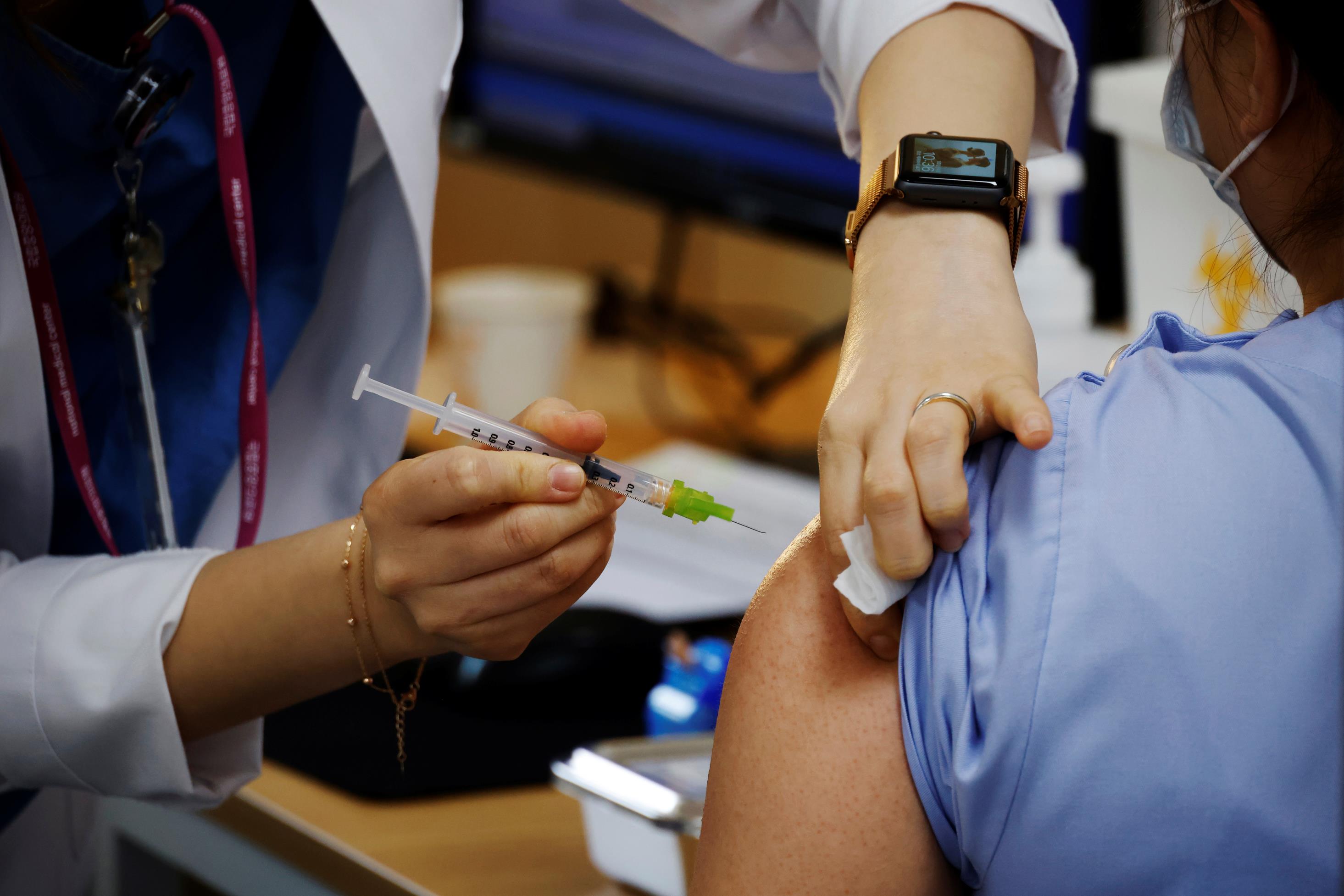 A health worker gets a dose of the Pfizer-Bio<em></em>nTech coro<em></em>navirus disease (COVID-19) vaccine at a COVID-19 vaccination center in Seoul, South Korea, March 10, 2021.   REUTERS/Kim Hong-Ji