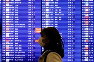 A woman wearing a mask to prevent co<em></em>ntracting coro<em></em>navirus walks past an electro<em></em>nic board showing flight schedules at Incheon Internatio<em></em>nal Airport in Incheon, South Korea, January 3, 2020.    REUTERS/Kim Hong-Ji