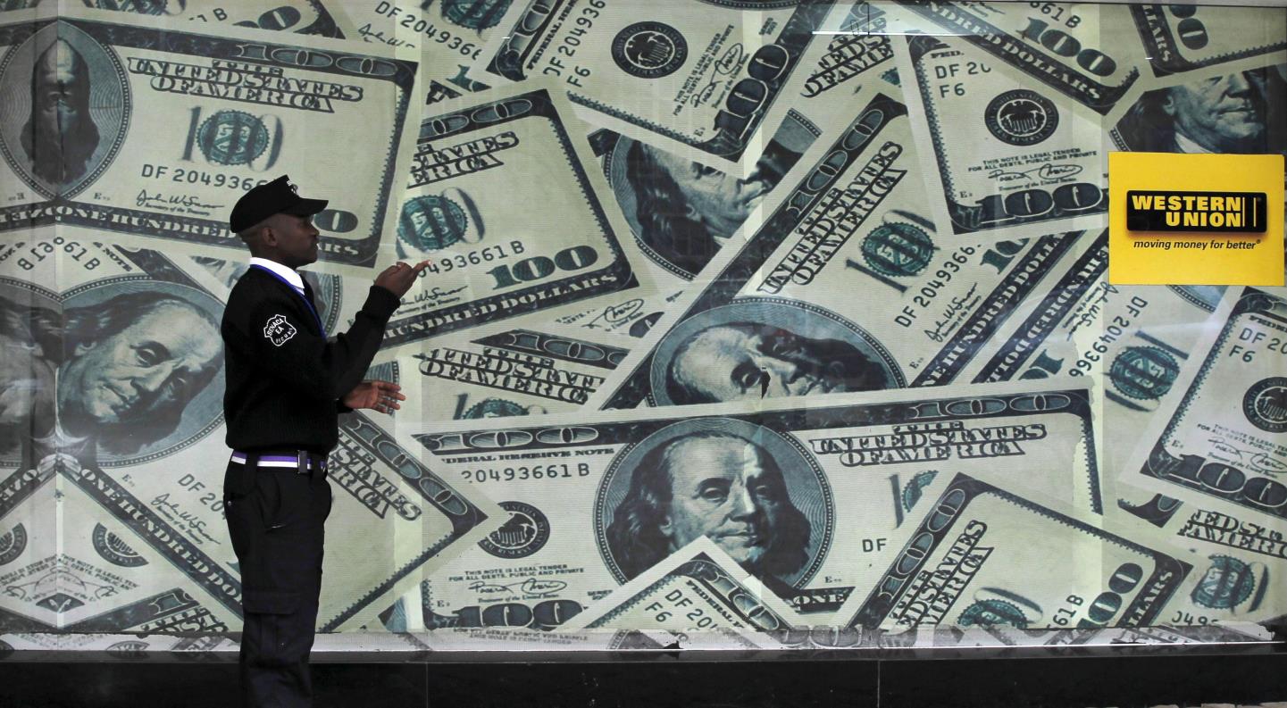 A security guard walks past a mo<em></em>ntage of old U.S. dollar bills outside a currency exchange in Kenya's capital Nairobi July 23, 2015. REUTERS/Thomas Mukoya