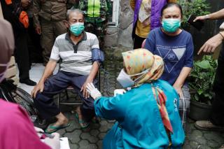Inan Rustandi, 72, and his wife Neneng, 62, locals of Sindanglaya village, undergo health screening before receiving their first dose of a COVID-19 vaccine, outside their house during a door-to-door vaccination in Cianjur regency, West Java province, Indonesia, June 15, 2021. REUTERS/Willy Kurniawan