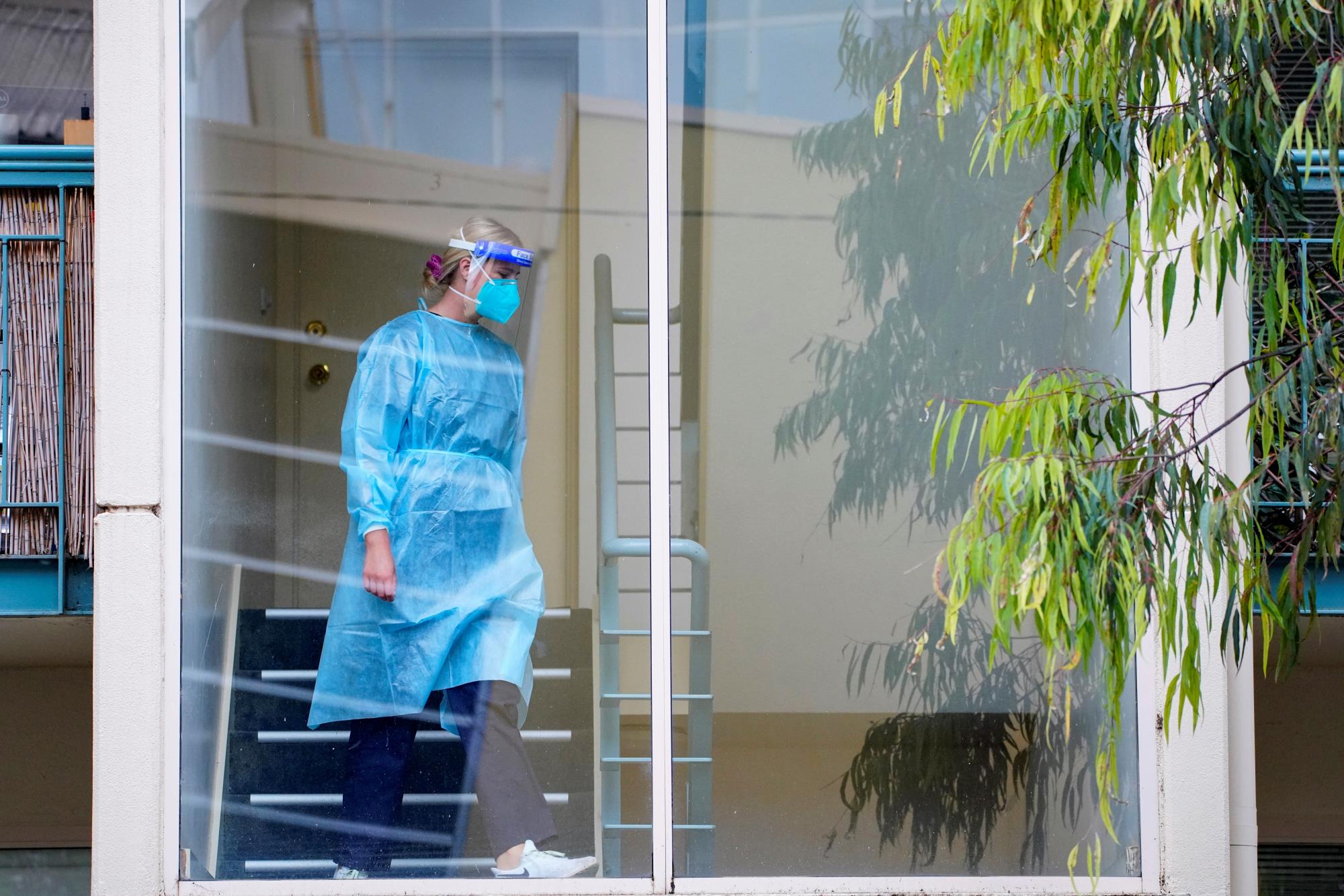 A healthcare worker walks down stairs at the Kings Park townhouse complex locked down in respo<em></em>nse to an outbreak of the coro<em></em>navirus disease (COVID-19), in Melbourne, Australia, June 16, 2021.  REUTERS/Sandra Sanders