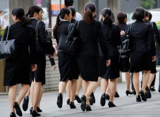 Female office workers wearing high heels, clothes and bags of the same colour make their way at a business district in Tokyo, Japan, June 4, 2019. REUTERS/Kim Kyung-Hoon/Files