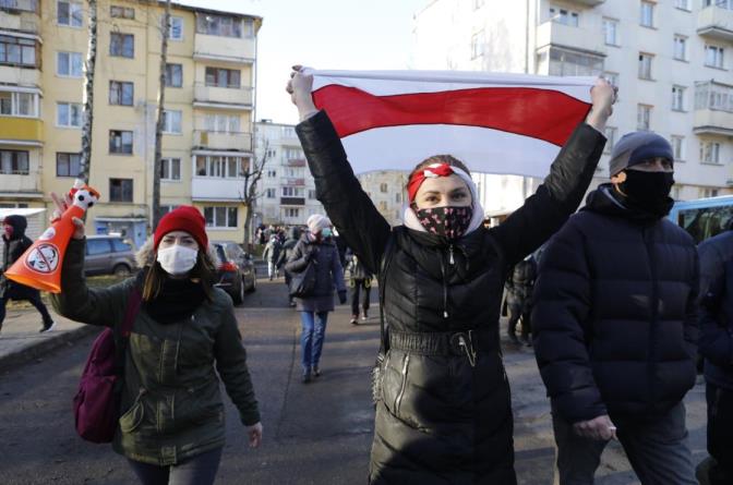 Demo<em></em>nstrators wearing face masks to help curb the spread of the coronavirus, wave an old Belarusian natio<em></em>nal flag, during an opposition rally to protest the official presidential election results in Minsk, Belarus, Sunday, Dec. 6, 2020. (AP File Photo)