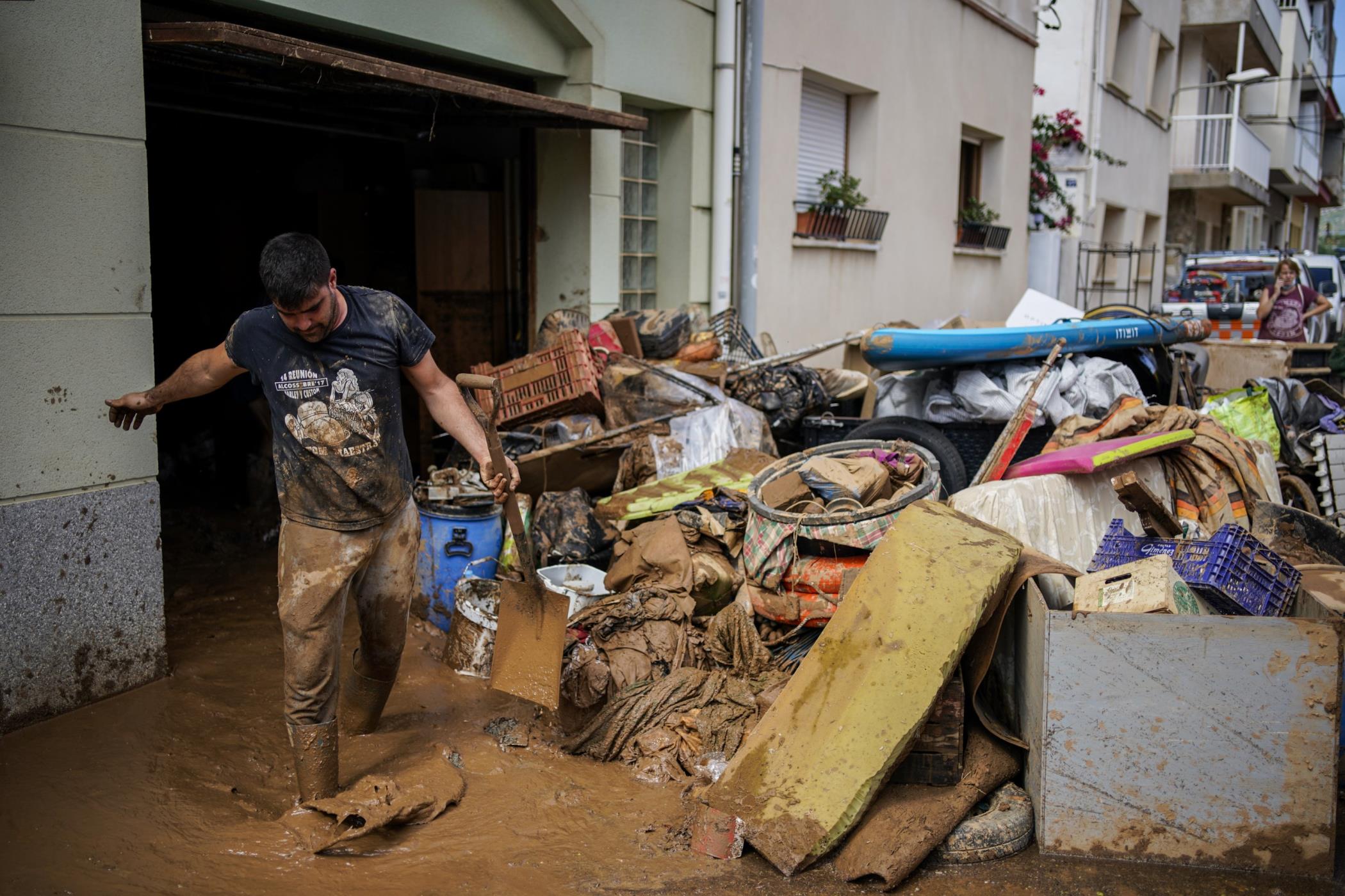 A man cleans up mud after flooding in a seaside town of Alcanar, in northeastern Spain, Sept. 2, 2021. (AP Photo)