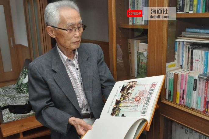Former Tadami Mayor Noboru o<em></em>numa looks at a book illustrating the opening day of the Tadami Line 50 years ago. | FUKUSHIMA MINPO
