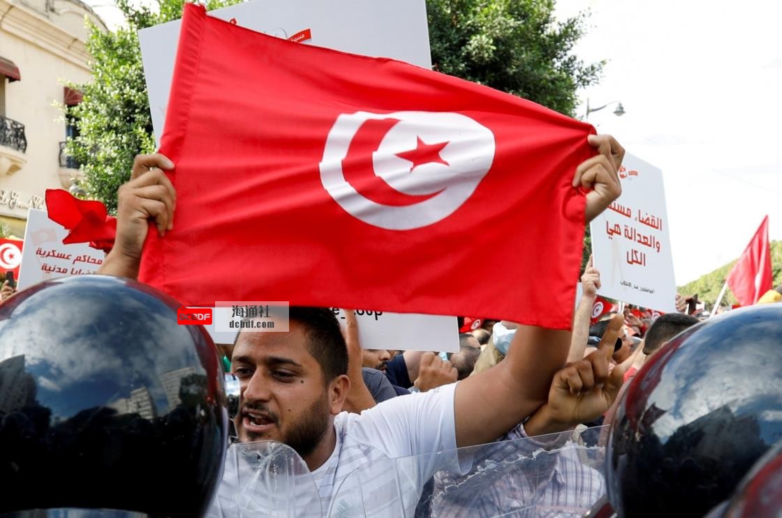 A demo<em></em>nstrator carries a Tunisian flag as he speaks with police during a protest against Tunisian President Kais Saied's seizure of governing powers, in Tunis, Tunisia, Oct. 10, 2021. (Reuters Photo)