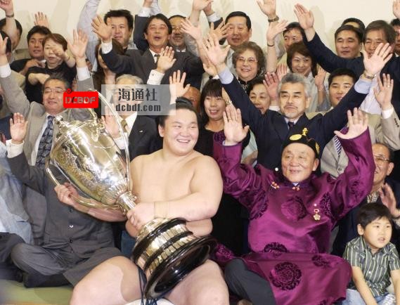 Then-ozeki Hakuho celebrates his first top-division title with supporters, including father Jigjidiin Mo<em></em>nkhbat (front right), after the 2006 May Basho at Ryogoku Kokugikan. | KYODO