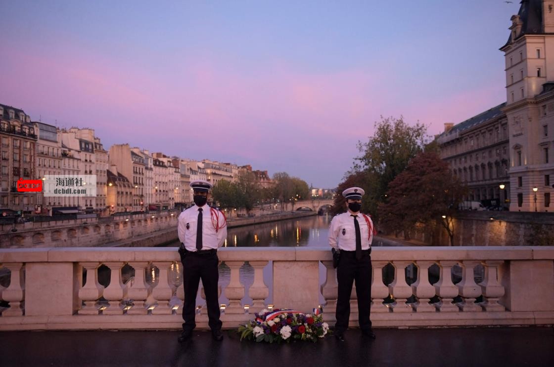 Police officers stand near a wreath of flowers on the Saint Michel bridge during a ceremony to commemorate France's brutal repression of an Oct. 17, 1961, anticolo<em></em>nialism demo<em></em>nstration wher<em></em>e at least 120 Algerians were killed, Paris, France, Oct. 17, 2021. (AFP Photo)